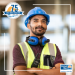 Image of 30-something Hispanic man in a construction uniform with arms folded and a hopeful look on his face.